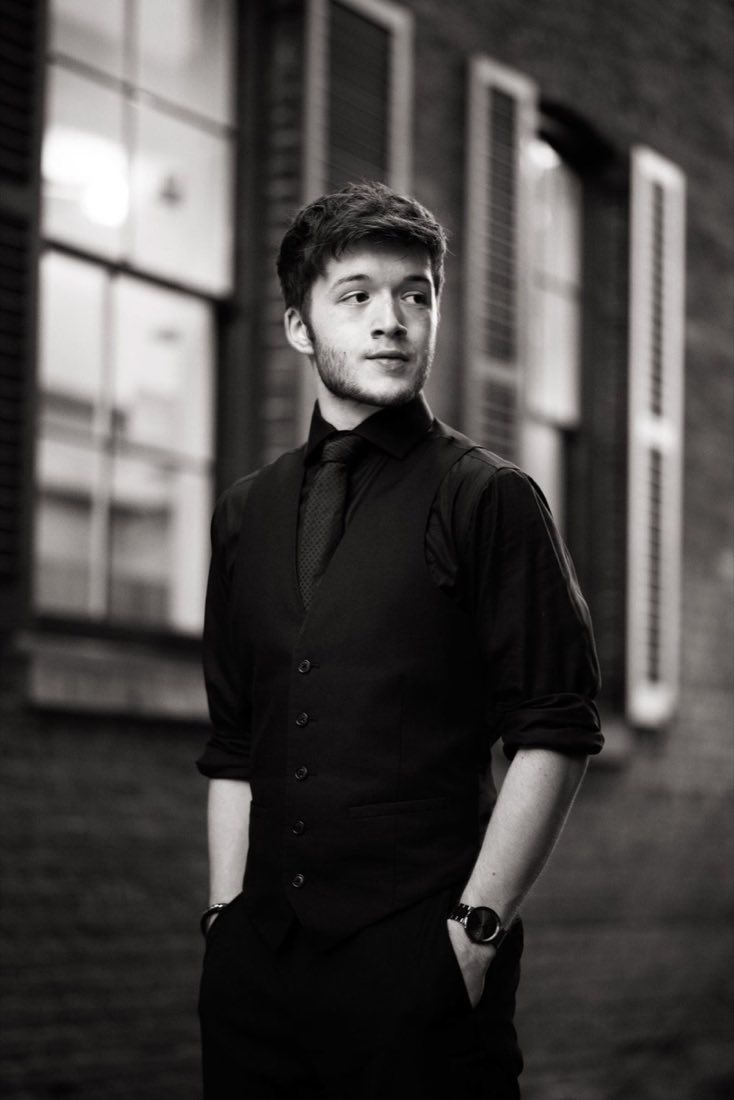 Black and white professional headshot against a brick wall