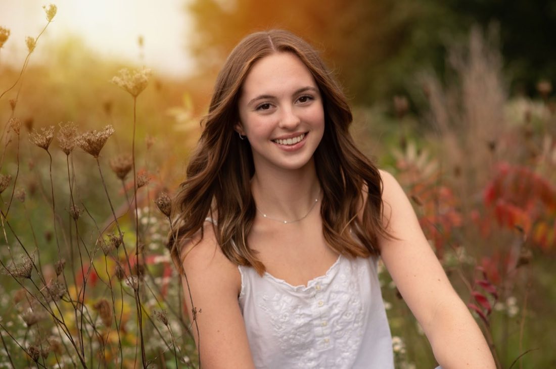 Senior portrait in a sunlit autumn meadow